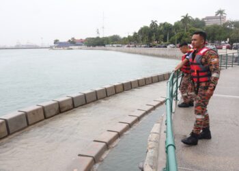 BEBERAPA anggota bomba dilihat memantau keadaan laut semasa bagi mengelakkan orang ramai daripada mengunjungi kawasan berisiko itu ketika fenomena air pasang di Pulau Pinang yang bermula semalam.-UTUSAN/IQBAL HAMDAN