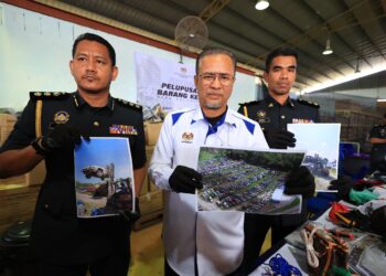 AZMAN Ismail (tengah) menunjukkan kereta dan kenderaan yang telah dirampas selepas digunakan untuk menyeludup bahan bakar ke Thailand semasa sidang media rampasan barangan kes di Stor Penyimpanan Barang Kes KPDN di Kandis, Bachok, Kelantan hari ini-UTUSAN/KAMARUL BISMI KAMARUZAMAN.