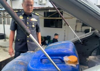 ANGGOTA KPDN Kelantan memeriksa tong jerikan selepas menahan sebuah kereta Proton Wira yang membawa 700 liter petrol seludup dalam serbuan di Lubok Jong, Rantau Panjang, Kelantan semalam.