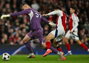 Penjaga gol Shaktar Donetsk, Dmytro Riznyk (kiri) diasak tonggak tengah Arsenal, Gabriel Martinelli dalam saingan Liga Juara-Juara di London pagi tadi. - AFP