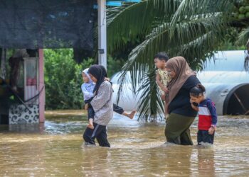 PENDUDUK mengharungi air di Kampung Kubang Betong yang dilanda banjir di Kubang Pasu. - UTUSAN/ SHAHIR NOORDIN