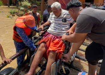 ANGGOTA Angkatan Pertahanan Awam Malaysia (APM) memindahkan mangsa banjir di Daerah Muallim hari ini. - UTUSAN/APM