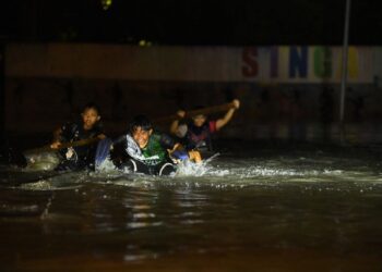 SEKUMPULAN kanak-kanak bermain air yang memenuhi kawasan perkampungan nelayan berikutan air pasang besar di Kampung Pulau Ketam, Kuala Perlis, semalam.-UTUSAN/IZLIZAN OTHMAN