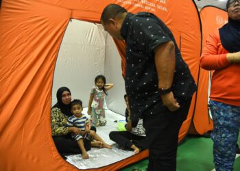 ABU Bakar Hamzah (dua dari kanan) meninjau mangsa yang ditempatkan di Pusat Pemindahan Sementara (PPS) Institut Kemahiran Belia Negara (IKBN) Kuala Perlis, Perlis, hari ini. -UTUSAN/ IZLIZAN OTHMAN