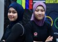 Nurul Aisyah Athirah Mohd Nadzim (kanan) dan Dhiya' Raihan Dzulkarnain berkongsi minat yang sama dalam sukan angkat berat. - UTUSAN/IZLIZAN OTHMAN