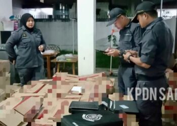 PEGAWAI penguat kuasa KPDN memeriksa barang kawalan yang dijual tanpa permit yang sah di sebuah rumah di Jalan Kobusak, Kota Kinabalu semalam