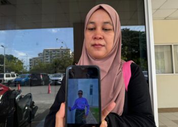 NUR Suraya Abdul Rahman menunjukkan gambar anaknya, Muhammad Hariyz Akief Noraimi, 14, yang meninggal dunia akibat terkena renjatan elektrik di Kampung Tanjung Putus, Kuala Nerang.