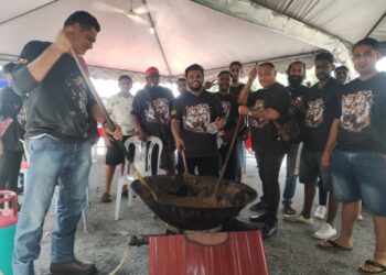 S. SATHEESH Kumar (lima dari kanan) dan Mohd. Noor Hakkim (kiri) bersama pemuda-pemuda masyarakat India bersama-sama mengacau dodol di Taman College Height, Sikamat, Seremban semalam.