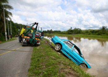 KERETA Proton Wira yang terjunam dinaikkan menggunakan trak penunda dari Sungai Santap di Pokok Sena. - UTUSAN/ SHAHIR NOORDIN