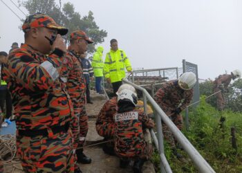 ANGGOTA bomba melakukan persediaan untuk turun ke bawah gunung bagi mencari mangsa yang terjatuh di kereta kabel Gunung Mat Chincang, Langkawi. - IHSAN BOMBA