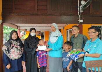 NOR Hanani Abdul Hamid (tengah) bersama Pengarah Langkawi SkyWalk Sdn. Bhd., Abd. Samad Ahmad (dua kanan) menyerahkan faedah Perkeso kepada Zunirah Othman (dua kiri) di Kampung Padang Kandang, Padang Matsirat, Langkawi.