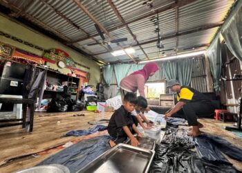 FARAH Umiah Abu Bakar, suami dan anak-anaknya menadah air hujan menggunakan bekas dan besen di Kampung Chengal Lempong di Kuantan, Pahang. – UTUSAN/NORHAFIZAN ZULKIFLI