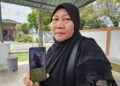 SAINA Binsa-i menunjukkan gambar suaminya, Adnan Ismail yang maut dibaham harimau dalam kejadian di rumah kongsi Bagan Balak di Gerik semalam.- UTUSAN