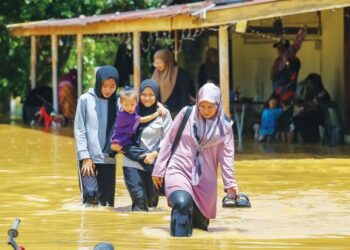 PENDUDUK di beberapa daerah Kubang Pasu meredah air banjir yang masih berlarutan sehingga kini ekoran hujan lebat dan air pasang besar ketika peralihan monsun. – UTUSAN/SHAHIR NOORDIN