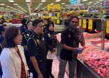 S. JEGAN (kanan) meneliti harga daging kambing di sebuah pasar raya di Seberang Jaya, Pulau Pinang, hari ini.