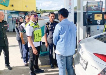 MUHAMMAD Nizam Jamaludin (tengah) melakukan pemeriksaan terhadap seorang pengguna yang memandu kenderaan berpendaftaran asing di sebuah stesen minyak berhampiran sempadan Malaysia-Thailand di Changlun, Kubang Pasu.