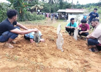 UZAIR Azman (dua, kanan) dan Abdul Raziq (dua dari kiri) kelihatan sugul setelah selesai pengebumian Puteri Sajidah Azman dan Siti Fatimah di Tanah Perkuburan Islam Kampung Panggung, Ajil, Hulu Terengganu , hari ini.  - UTUSAN/NOOR HAYATI MAMAT