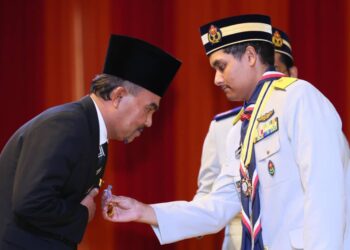 TENGKU Muhammad Ismail (kanan) menganugerahkan Pingat Cemerlang Pengakap Darul Iman kepada Presiden Kelab Wartawan Media Terengganu (Kawat), 
Ahmad Syafri Husnaini Mohamad di Kuala Terengganu, hari ini. - UTUSAN/KAMALIZA KAMARUDDIN