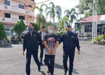 PENGERUSI masjid (tengah) yang direman selepas disyaki melakukan salah guna kuasa dibawa keluar dari Mahkamah Majistret Kemaman, hari ini. - UTUSAN/NIK NUR IZZATUL HAZWANI NIK ADNAN