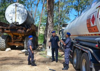 SAHARUDDIN Mohd. Kia (tengah) melihat lori tangki dan tangki skid yang dirampas dalam satu serbuan di tapak Projek Pemuliharaan Muara Sungai Setiu, Kampung Mangkuk, Setiu, hari ini. - UTUSAN/PUQTRA HAIRRY ROSLI