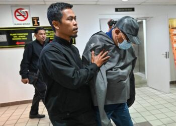 MOHD. Hisham Daud (kanan) mengaku bersalah kemuka tuntutan palsu dibawa keluar dari Mahkamah Sesyen Kuala Terengganu, hari ini. - UTUSAN/PUQTRA HAIRRY ROSLI