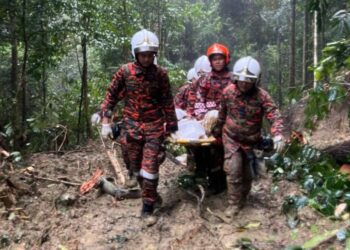 ANGGOTA bomba mengusung mayat Daeng Latif Daeng Nurun yang maut dihempap pokok di Hulu Paka, Dungun, Terengganu, semalam.