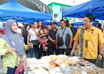 EWON Benedick (kanan) semasa beramah mesra dengan peniaga Tamu Donggongon di Penampang semalam.