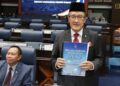 MASIDI Manjun menunjukkan Belanjawan Negeri 2025 semasa tiba di DUN Sabah di Kota Kinabalu hari ini