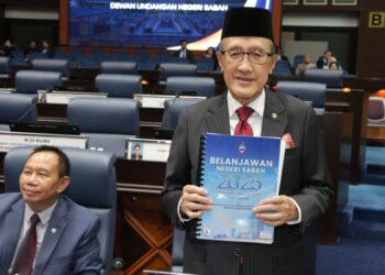 MASIDI Manjun menunjukkan Belanjawan Negeri 2025 semasa tiba di DUN Sabah di Kota Kinabalu hari ini