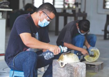 SAIFUL Sani Zakaria melakukan proses mencanai periuk tembaga di Pusat Inkubator Kraftangan Malaysia Cawangan Terengganu, di Chendering, Kuala Terengganu. – UTUSAN/PUQTRA HAIRRY ROSLI