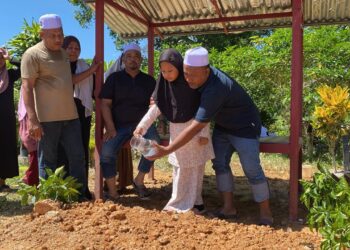 IMAN Nur Hannan Mohamad Khairul Hakim menyiram air mawar pada kubur bapanya di Tanah Perkuburan Islam Kampung Bukit, Jalan Naka di Pokok Sena hari ini.