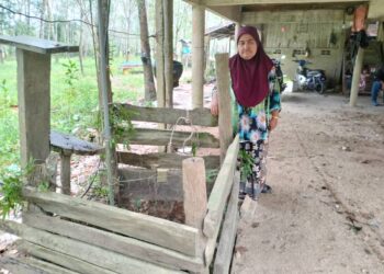 NORMA Mohd Nor menunjukkan lokasi suaminya, Bahrum Ismail terjatuh kedalam perigi di Kampung Tasek Bakong, Rantau Panjang, Kelantan-UTUSAN/ROHANA ISMAIL.