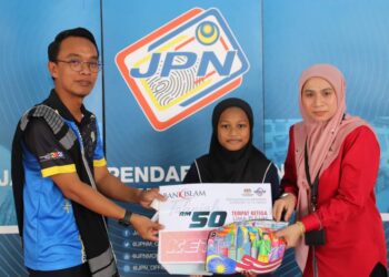 MOHAMAD Nasir Kareem (kiri) menyampaikan hadiah kepada pemenang pertandingan mewarna pada program Mekar Komuniti Monsun JPN Terengganu di Kuala Terengganu, hari ini. - UTUSAN/KAMALIZA KAMARUDDIN