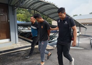 MUHAMMAD Shafiq Abdullah (tengah) dibawa ke Mahkamah Majistret Kuala Pilah hari ini bagi berdepan pertuduhan menggunakan wang palsu minggu lalu.-UTUSAN/NOR AINNA HAMZAH.