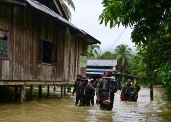 ANGGOTA Batalion Ke-18 RAMD membantu mangsa banjir berpindah dalam Ops Murni di Kampung Tengkawang, Kuala Berang, Hulu Terengganu, hari ini. - UTUSAN/PUQTRA HAIRRY ROSLI