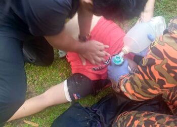 ANGGOTA bomba dan kakitangan Kementerian Kesihatan Malaysia (KKM) memberikan bantuan CPR kepada mangsa lemas di Sungai Kampar, Gopeng hari ini. - UTUSAN/IHSAN JBPM PERAK