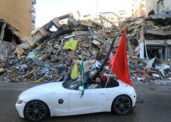 SEORANG pemandu mengibarkan bendera Hezbollah ketika menyertai perarakan di pinggir bandar selatan Beirut.-AFP