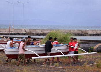 PENDUDUK dan nelayan di Bandar Legaspi, wilayah Albay mengangkat bot kayu ke tempat selamat selepas amaran Taufan Super Man-yi dikeluarkan, semalam.- AFP