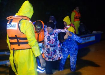 ANGGOTA APM Kuala Pilah menyelamatkan mangsa terjejas banjir untuk dibawa ke PPS yang telah dibuka sejak awal pagi tadi.-GAMBAR/IHSAN APM KUALA PILAH