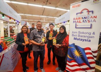 ADIRATNO Che Ani (dua kiri) menunjukkan antara produk tempatan selepas merasmikan Kempen Beli Barangan Malaysia (KBBM) di AEON Big Putrajaya. -  UTUSAN/FAISOL MUSTAFA