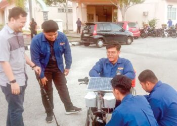 NOOR Asyraf  Ariffin (kiri) dan Muhammad Alif Wajdy Baharom (dua dari kiri) bersama tiga rakan melihat kerusi roda solar di IKML di Seri Manjung, Perak semalam. –  UTUSAN/SHAMSUL KAMAL AMARUDIN