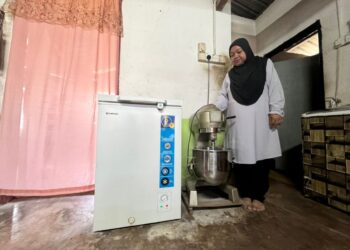 MARIAM Jusuh akan menyelamatkan mesin mengadun doh kuihnya terlebih dahulu setiap kali rumahnya dinaiki air banjir di Kampung Belukar di Kuantan, Pahang. – UTUSAN/NORHAFIZAN ZULKIFLI