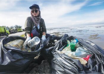 ROSNANI Nazri menunjukkan sisa plastik yang dikutipnya di Kuala Perlis, baru-baru ini.