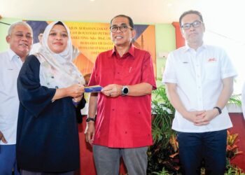 MOHAMED KHALED Nordin dan Azizul Azily Ahmad (kanan) bersama penerima Zakat Wakalah Boustead Petroleum Marketing Sdn. Bhd. di Masjid Muhajirin, Masai, Pasir Gudang semalam.