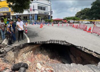 KERK CHEE YEE melihat lubang benam sedalam hampir dua meter yang berlaku di hadapan Balai Polis Ayer Keroh, Melaka.