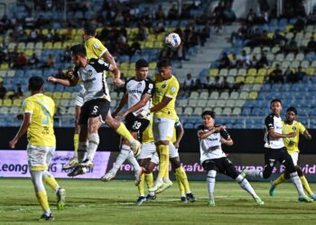 PENYERANG TFC, Nelson Bonilla (99) menanduk bola sambil diasak pertahanan Penang FC, Khairun Akmal Rokisham dalam aksi Liga Super di Stadium Sultan Mizan Zainal Abidin, Kuala Nerus, malam ini. - UTUSA/PUQTRA HAIRRY ROSLI