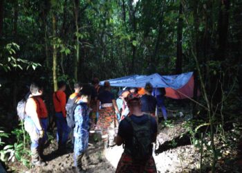 ANGGOTA polis bersama pasukan penyelamat membawa seorang lelaki OKU yang meninggal dunia keluar dari kawasan hutan Jabi, Kampung Redan di Lipis, Pahang - FOTO/IPD LIPIS