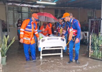 PASUKAN penyelamat membantu memindahkan seorang mangsa banjir yang terlantar di kawasan Rumah Mampu Milik Telung Kalong, Kemaman, petang ini. - UTUSAN/NIK NUR IZZATUL HAZWANI NIK ADNAN