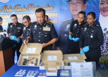 YAHAYA Othman (depan) menunjukkan pistol dan dadah yang dirampas selepas menahan lima lelaki dalam serbuan di sebuah rumah sekitar bandar pusat Jengka di Maran, Pahang. - FOTO/SALEHUDIN MAT RASAD