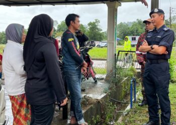 KETUA Polis Terengganu, Datuk Mohd.  Khari Khairudin (kanan) bertanya khabar mangsa banjir di Perumahan Taman Rakyat Teluk Kalong, Kemaman, semalam. - UTUSAN/PUQTRA HAIRRY ROSLI